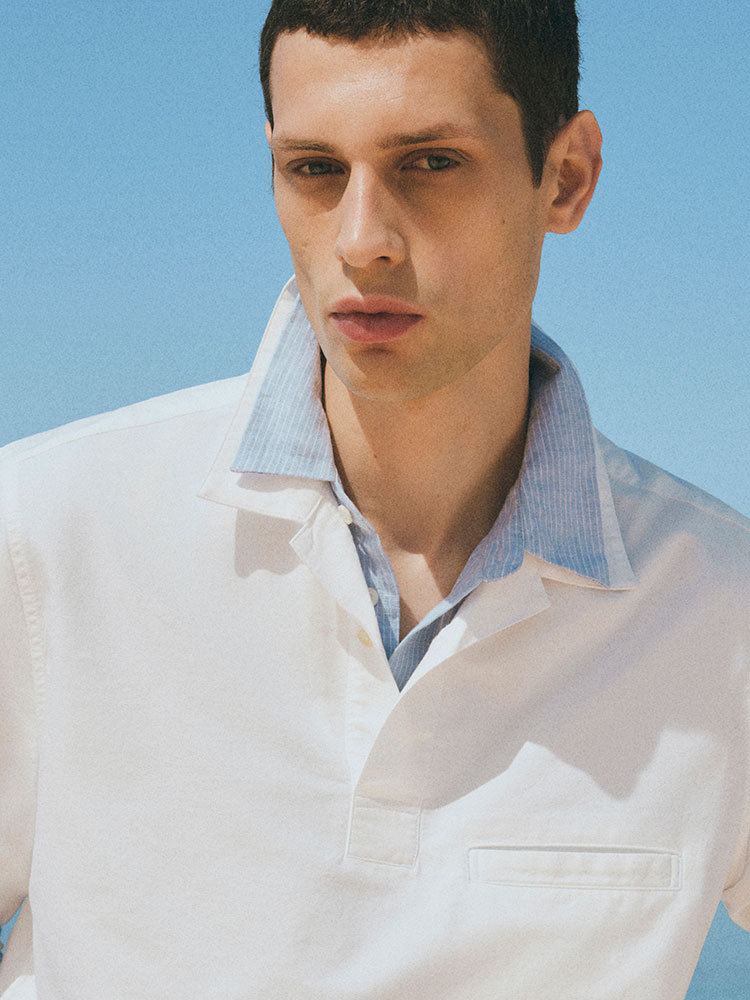 man wearing turtleneck standing on balcony